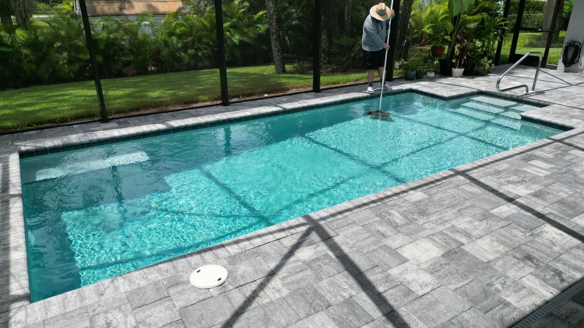 A pool with a tile floor and a glass door.