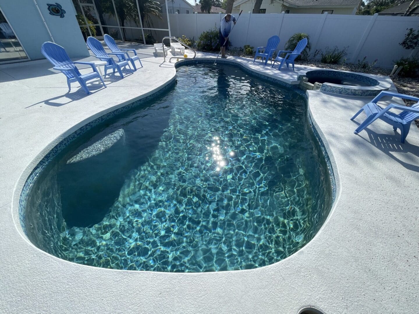 A pool with chairs and blue chairs in the back ground